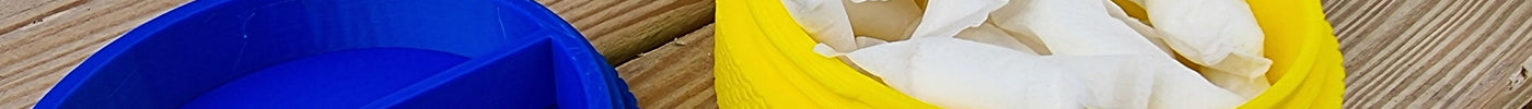 Open yellow pouch holder filled with nicotine pouches beside blue divider puck and ZYN tin