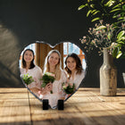 Freestanding heart-shaped photo slate displaying a wedding photograph on a wooden shelf