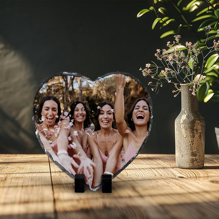Freestanding heart-shaped photo slate displaying a wedding party photograph on a wooden shelf