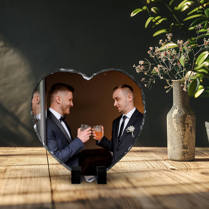 Freestanding heart-shaped photo slate displaying a groom photograph on a wooden shelf