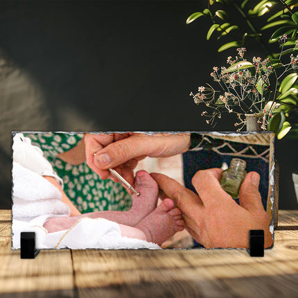 Freestanding rectangular photo slate displaying a christening photograph on a wooden shelf