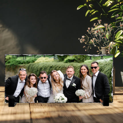 Freestanding rectangular photo slate displaying a groom photograph on a wooden shelf